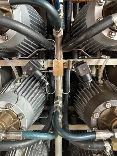 Replacement capillary pipes installed on the pressure manifold of a Nilfisk Delta Booster multi-pump pressure washer after repair.